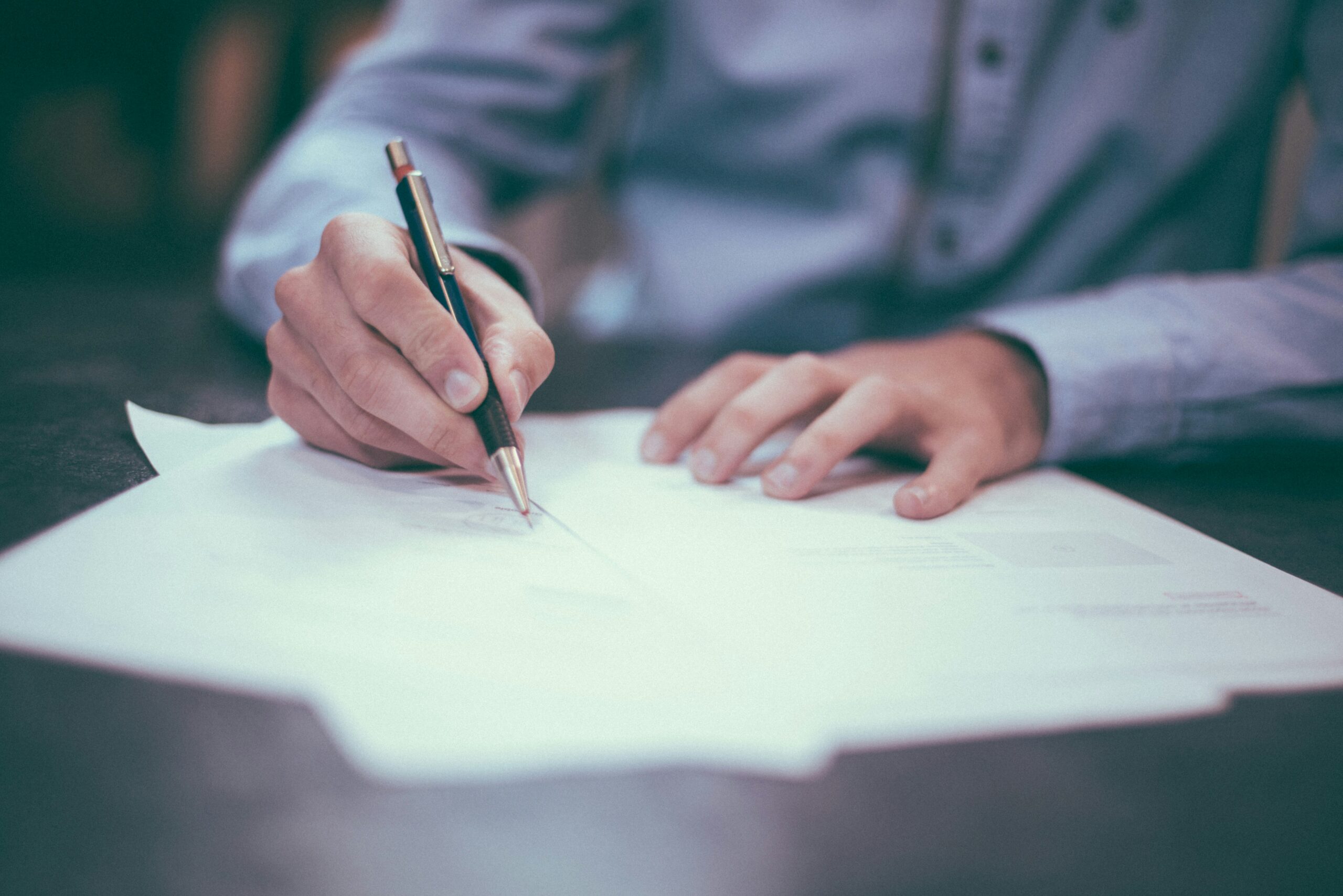 person signing his life insurance agreement