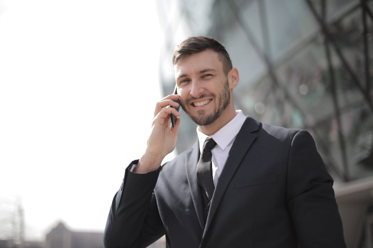 A businessman smiling while holding his phone