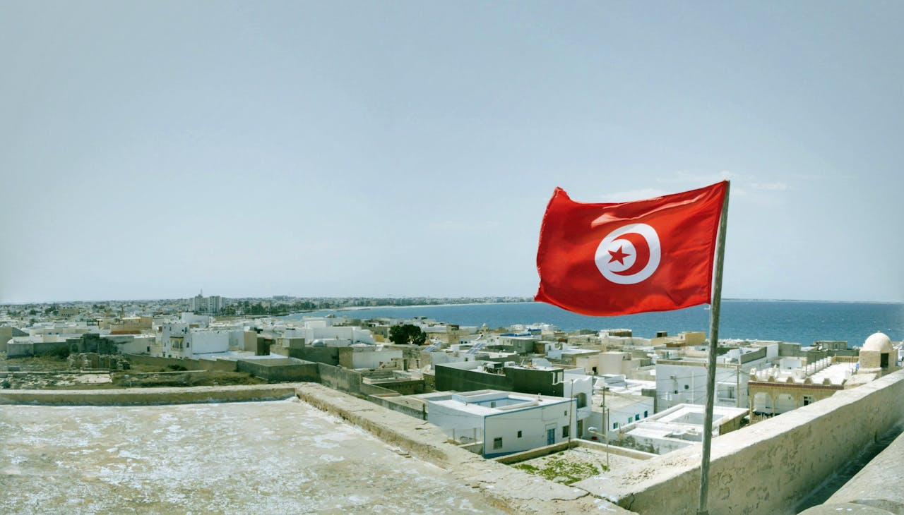 The flag of Tunisia with buildings in the background