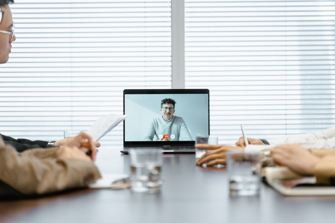 A group of people huddled and listening to a consultant online
