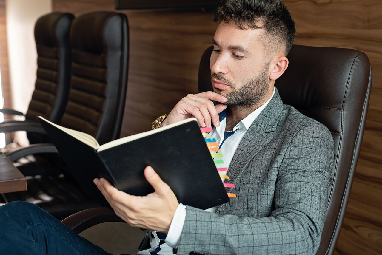 Businessman in suit reading notebook