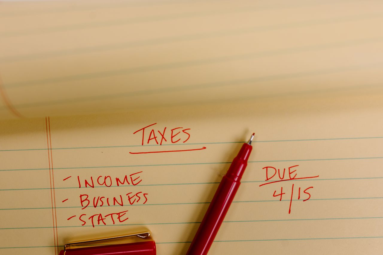 Close-up of tax-related notes on a yellow legal pad with red pen