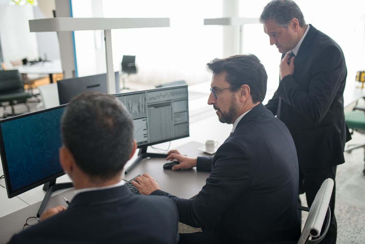 Colleagues in a modern office reviewing stock market trends and data